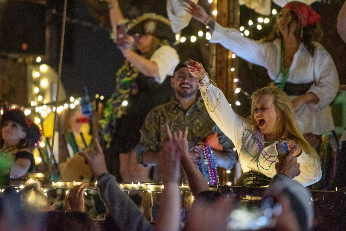 Float riders dressed as pirates throw beads to the crowd during the Ocean Springs Carnival Association Night Parade in Ocean Springs on Friday, Feb. 25, 2022.