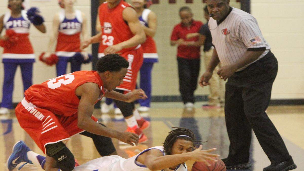 JOHN FITZHUGH/SUN HERALD 
 A referee watches as Pascagoula's Jakwaize Walker and Biloxi's Martell Turner dive for a loose ball during the second quarter of their game at Pascagoula High on Dec. 9, 2015.