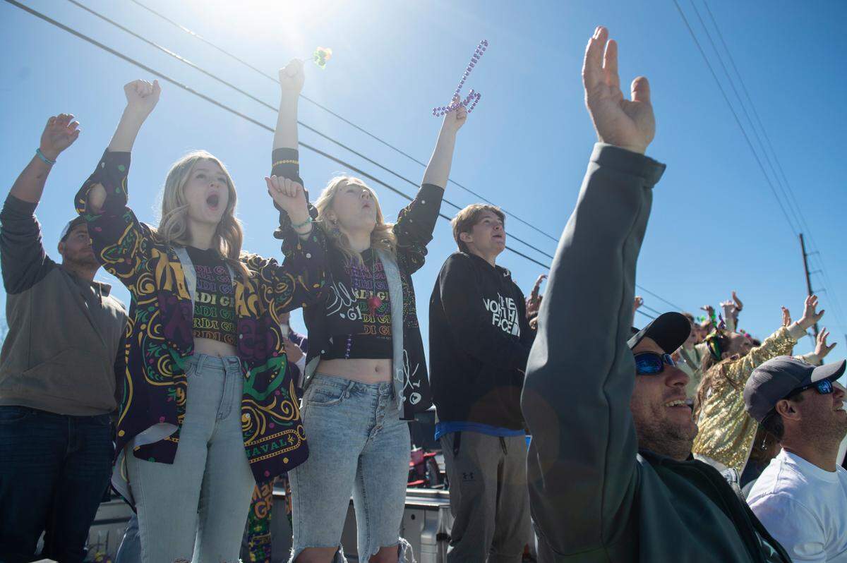 Parade watchers cheer as floats go by during the Krewe of Nereids Mardi Gras parade on Highway 90 in Bay St. Louis on Sunday, Feb. 12, 2023.