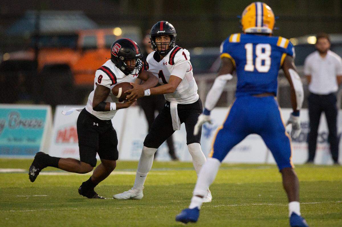 St. Stanislaus quarterback Ian Gael Gonzalez Rioz passes the ball off to Joshua Hartl during a game at Bay High in Bay St. Louis on Friday, Sept. 1, 2023.