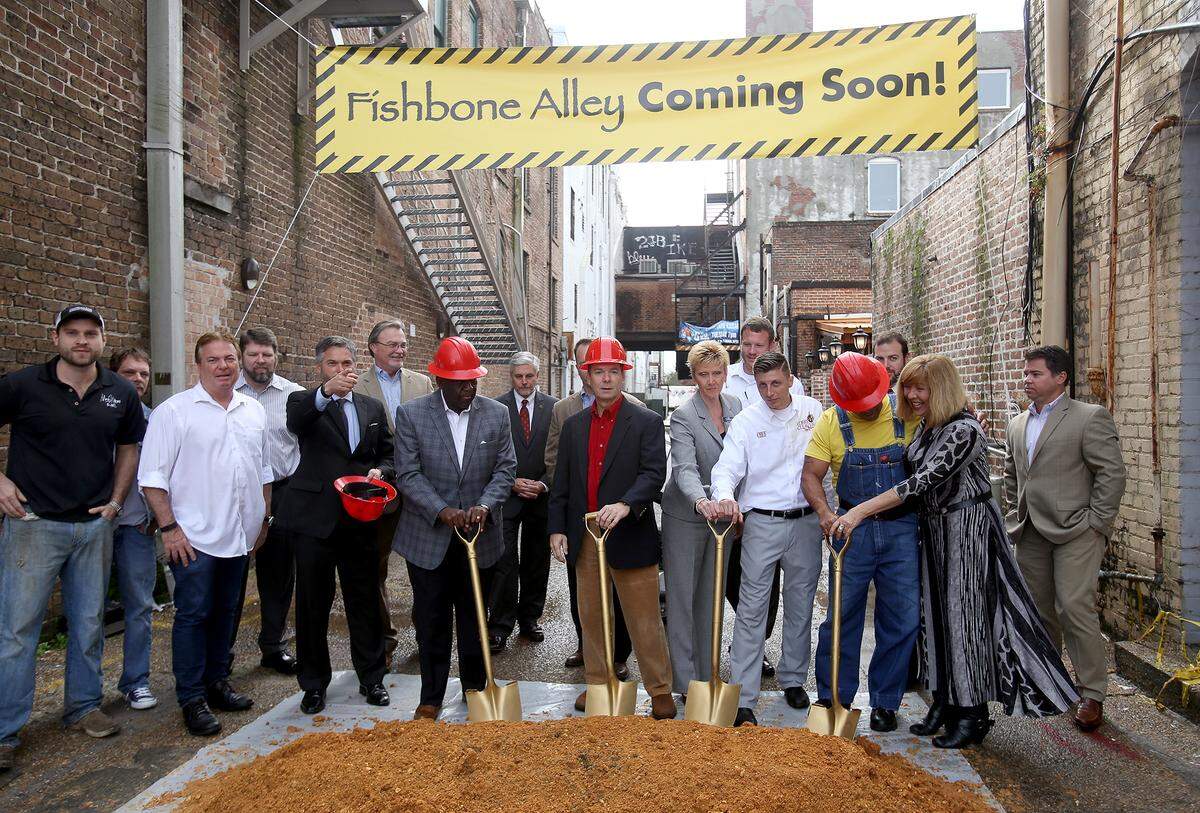 AMANDA McCOY/SUN HERALD/FILE  City officials and business owners break ground on Fishbone Alley in December. The downtown pedestrian alley could be part of a leisure district that a new state law would allow specified cities, including those on the Coast, to create. Within the district, customers could walk from one business to another with alcoholic drinks in go cups.