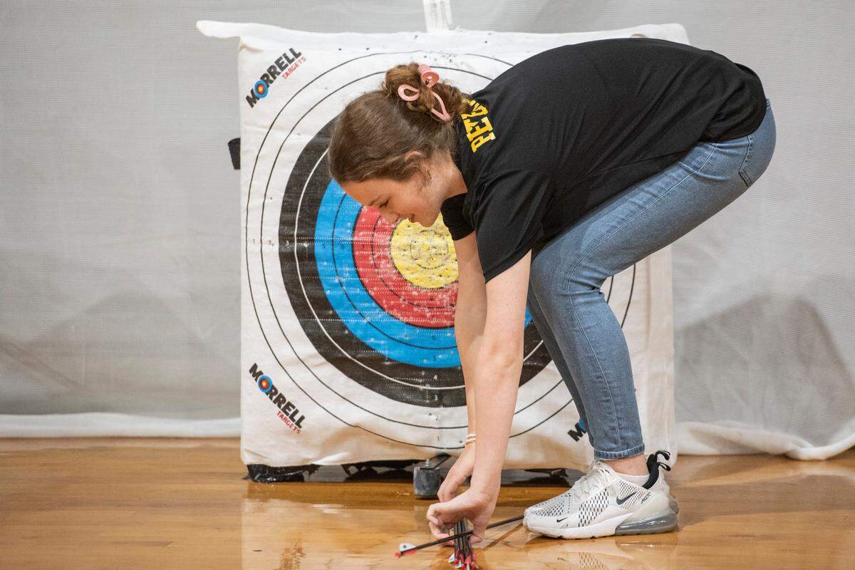 Eleventh grader Avary Peterson, a member of the D’Iberville High School archery team, retrieves her arrows during a practice at D’Iberville High School on Thursday, April 18, 2024.