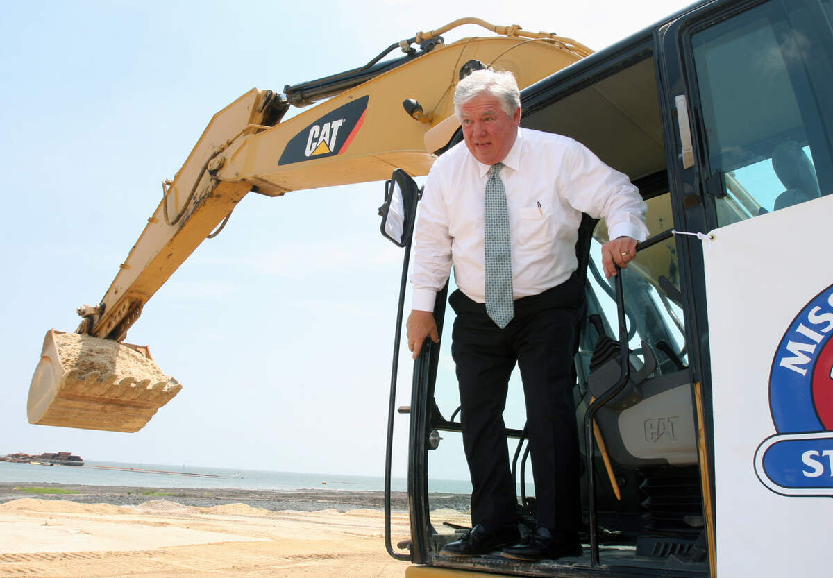 Gov. Haley Barbour steps out of a backhoe cockpit after last-minute instructions on operating it. The photograph was taken in July 2009 before a "ground-making ceremony” at the West Pier of the state port in Gulfport. The event kicked off a $570 million port restoration that failed to meet the economic development goals that the governor had hoped.