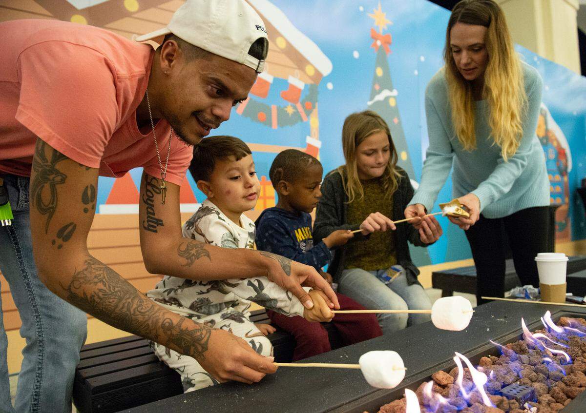 From left, Christopher Bunch, Christopher Bunch Jr., 4, Jaquon Bunch, 5, Aidyn Wyatt, 11, and Heather Wyatt, all of Saucier, make s’mores at Barksdale Pavilion at Jones Park during the Harbor Lights Winter Festival in Gulfport on Thursday, Dec. 2, 2021.
