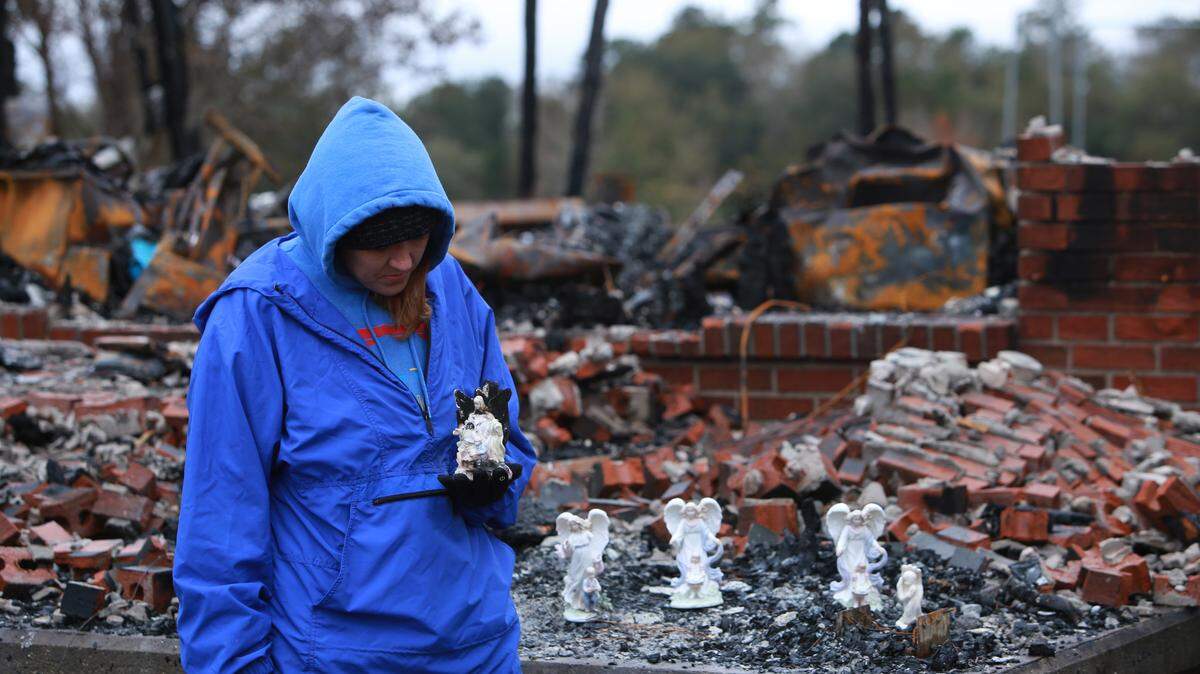 Leigh Haas, 30, holds an angel figurine that was burned but surived a fire that destroyed the Haas family’s home in Kiln, Mississippi on November 26, 2018.