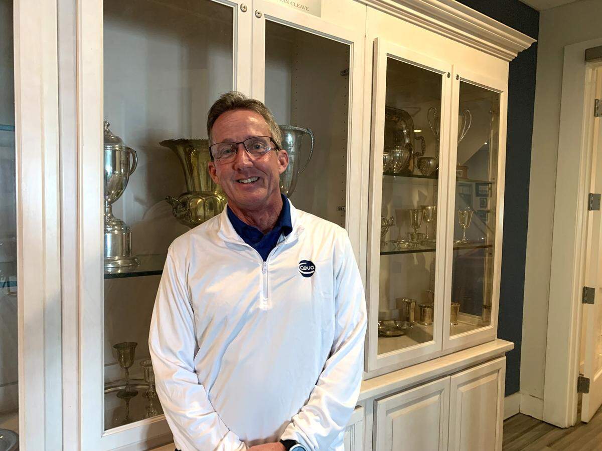 Tim Manuel, 2024 commodore at the Biloxi Yacht Club, stands near a case of trophies and awards. The building was sold, but the yacht club will remain there for at least a year.