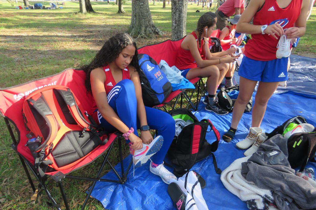 Leandra Ruiz, a top runner at Pascagoula High School, puts on her spikes before the regional cross country meet on Oct. 26, 2021.