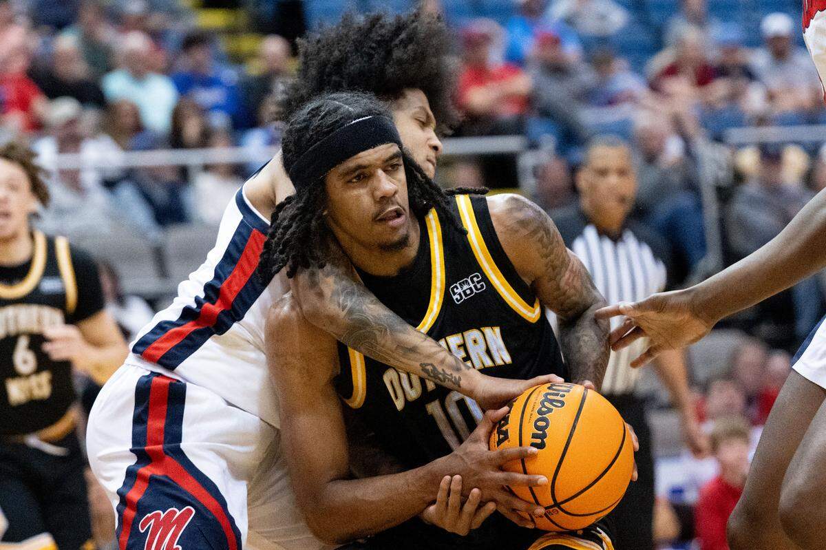 Southern Mississippi guard Isaac Taveras (10) pivots away from Mississippi defenders.