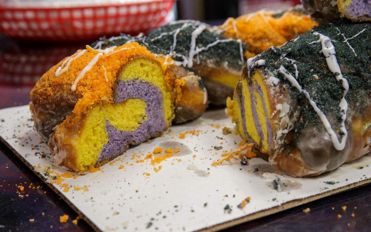 Doughnut maker Joshua Dean, created a Joe Burrow-inspired king cake with Bengals colors outside, LSU colors within at his shop, Little J’s Donuts in Harahan, La. Friday, Feb. 11, 2022.