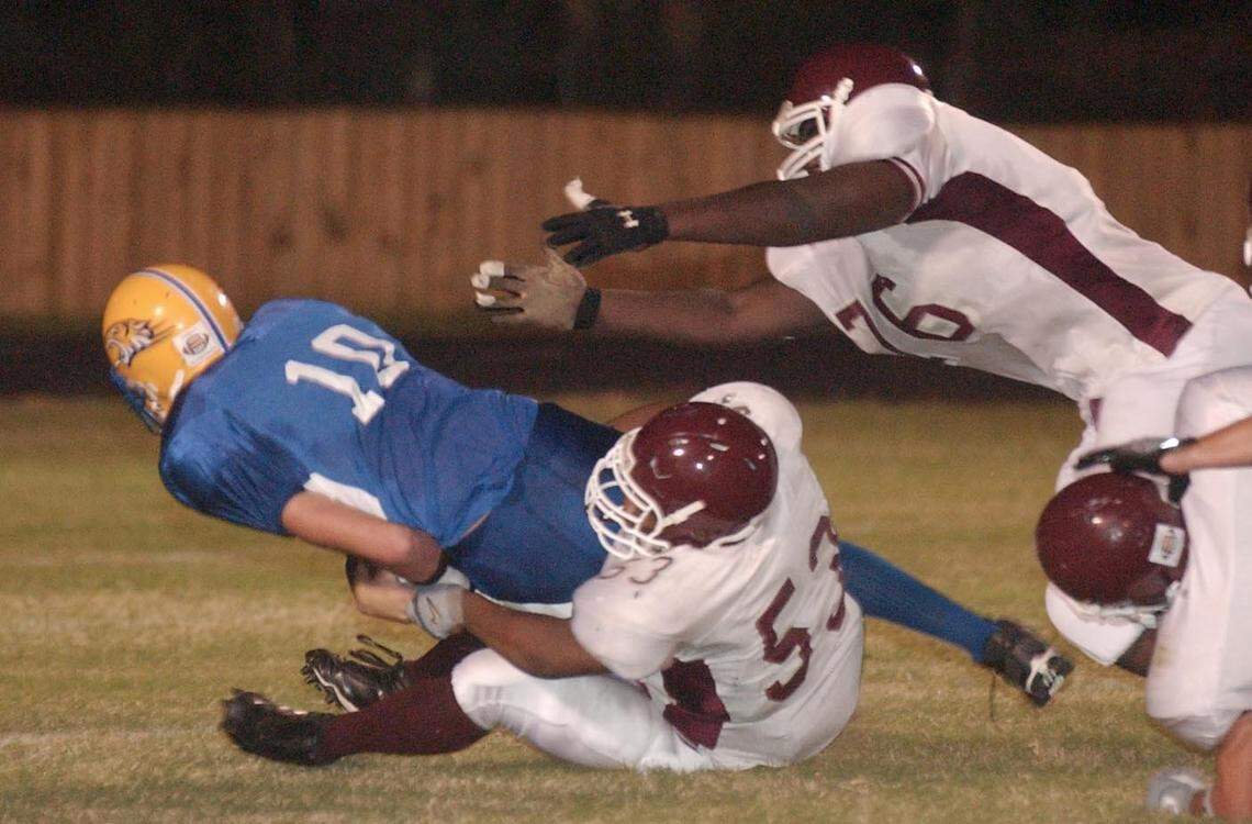 Long Beach defensive linemen Jonathan Green (53) and Cruz Johnson( 76) sack Bay High quarterback Tyler Brush(10) during the first-quarter of the Sept 26, 2005, game in Bay St. Louis.