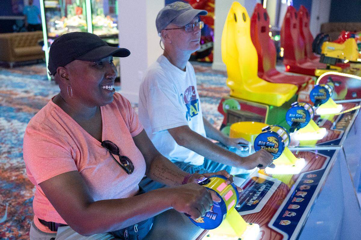 Visitors play arcade games during the grand opening of Hippie Fish at Centennial Plaza in Gulfport on Thursday, June 26, 2025.