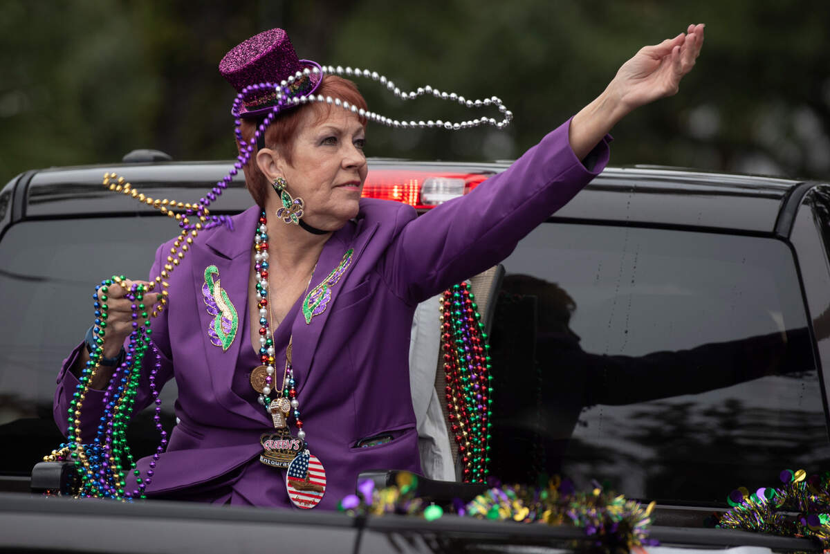 A member of parade royalty throws beads during The Ocean Springs Elks Carnival Parade in downtown Ocean Springs on Saturday, Jan. 27, 2024.