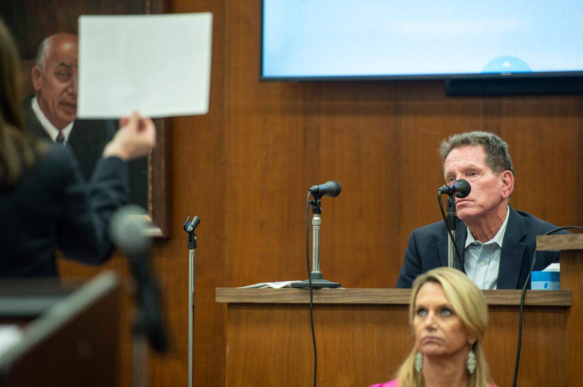 Assistant district attorney Alison Baker shows Cliff Kirkland a photograph of his alleged victims as he testifies on the witness stand during his trial for molesting underage girls in Harrison County Circuit Court in Biloxi on Tuesday, May 17, 2022.