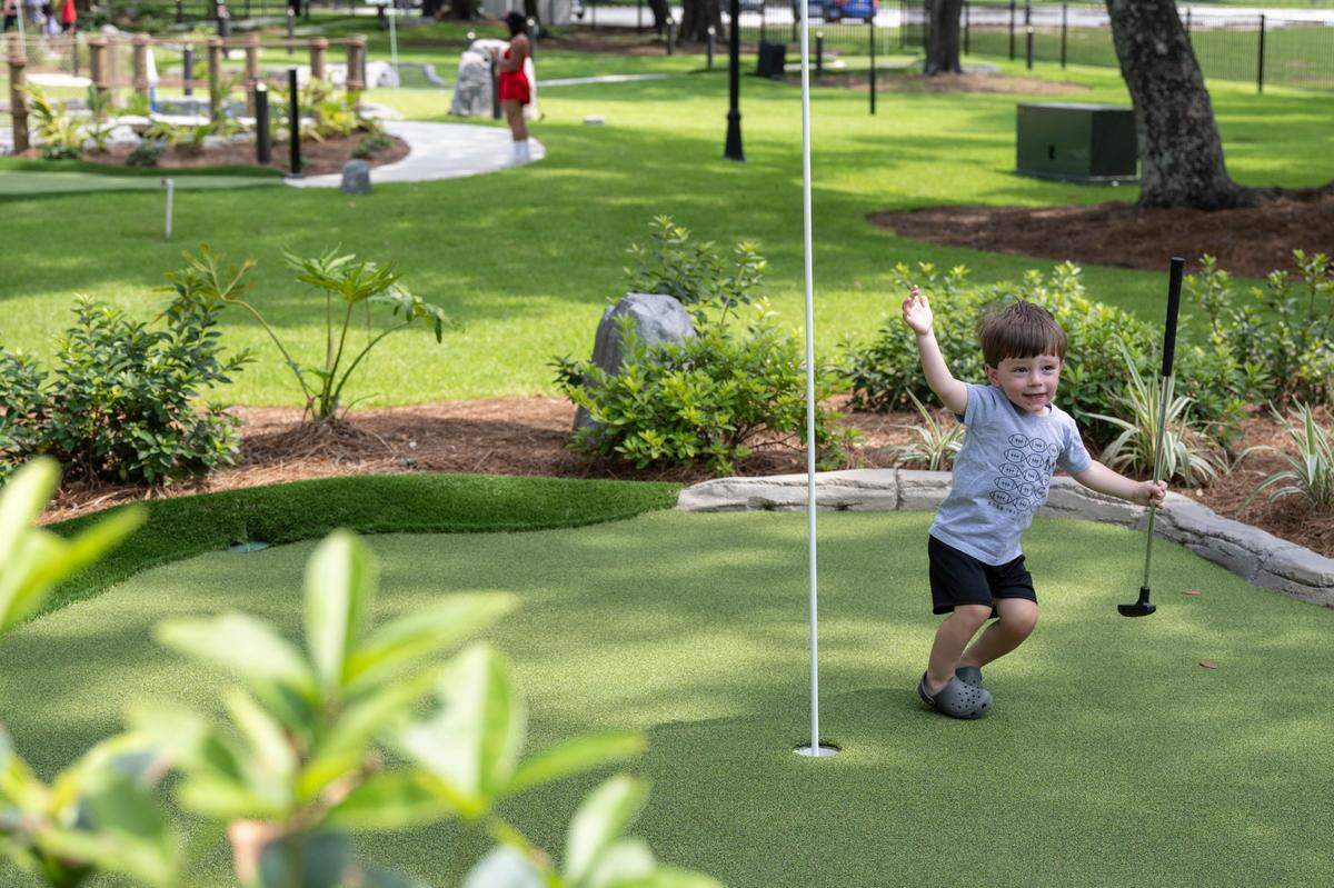A visitor reacts to his putt on the mini golf course at Hippie Fish at Centennial Plaza in Gulfport on Thursday, June 26, 2025.