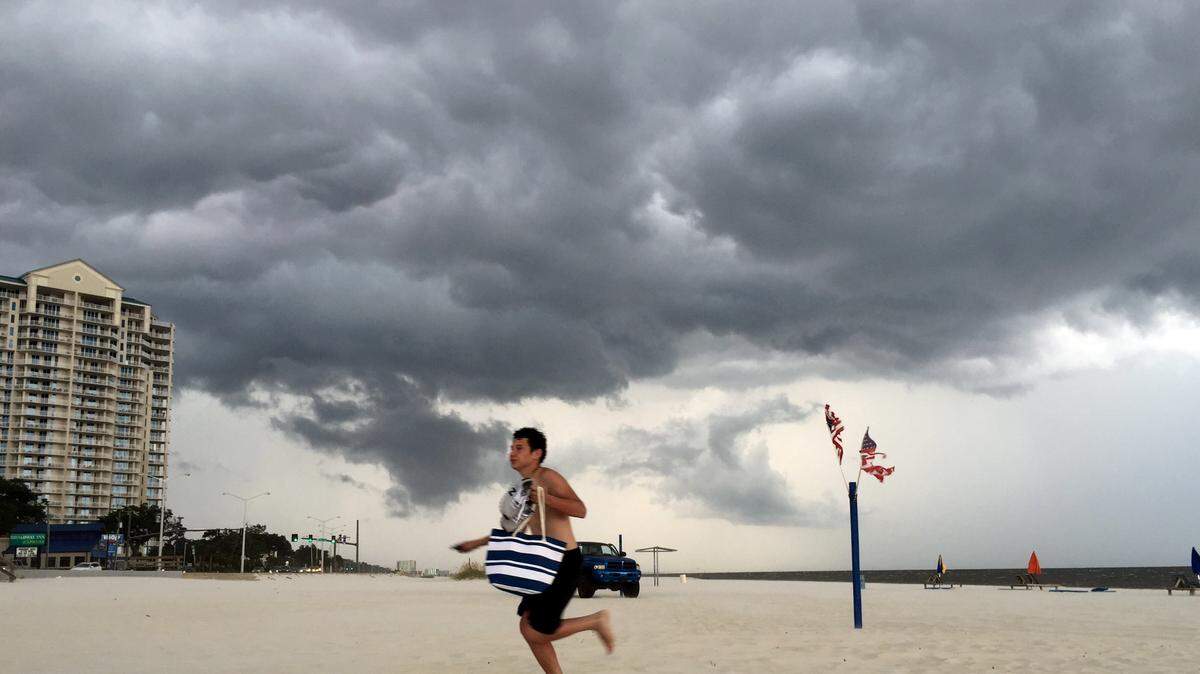 JOHN FITZHUGH/SUN HERALDMichael Medina of Richland runs for cover as a storm approaches in Biloxi on Sept. 6. 
 Photographer's comment: This is one of two of my favorites that was shot with my cellphone. I love the imposing sky as the tourist runs for cover.