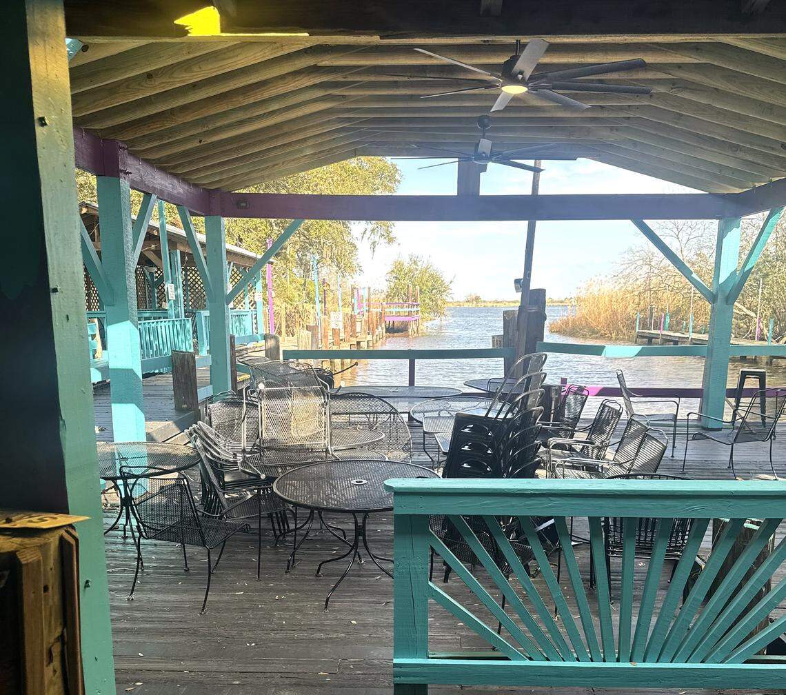 Half of the deck seating is covered at Crawfish House on the Bayou, providing shade while focusing the views out to the river.