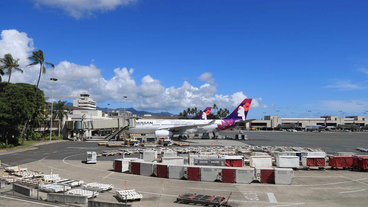 An airplane is seen parked at a terminal at the the Daniel K. Inouye International Airport Thursday, Oct. 15, 2020, in Honolulu. A new pre-travel testing program will allow visitors who test negative for COVID-19 to come to Hawaii and avoid two weeks of mandatory quarantine. (AP Photo/Marco Garcia)
