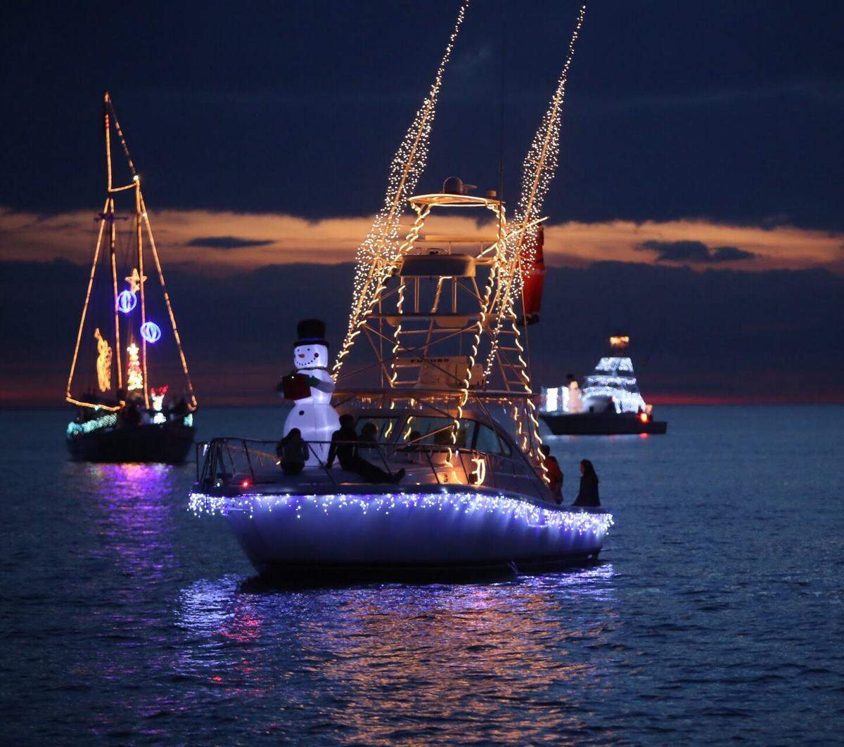 Boats decorated with Christmas lights participate in Biloxi’s Christmas on the Water boat parade in 2015.