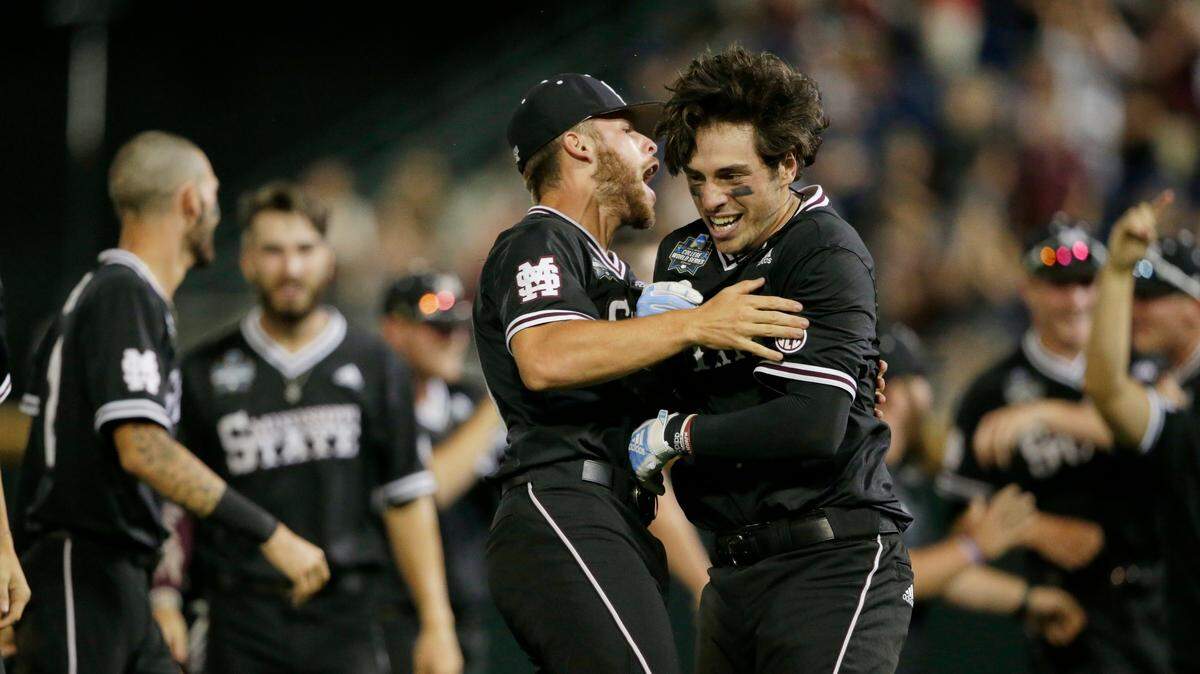 Mississippi State’s Marshall Gilbert, right, is hugged by Luke Hancock after Gilbert drove in the winning run against Auburn in the ninth inning of an NCAA College World Series baseball game in Omaha, Neb., Sunday, June 16, 2019. Mississippi State won 5-4.