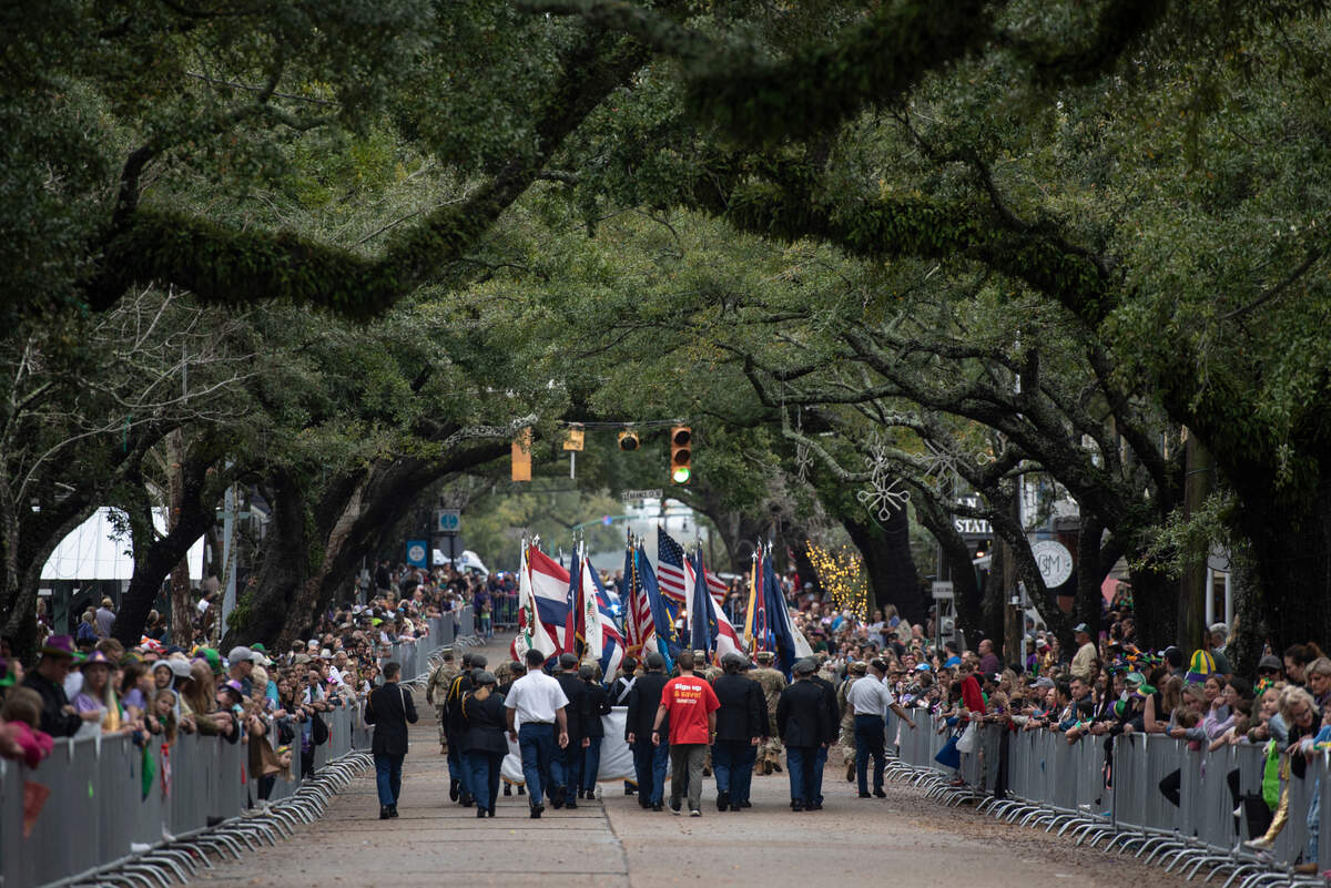 Military members carry flags of different states during The Ocean Springs Elks Carnival Parade in downtown Ocean Springs on Saturday, Jan. 27, 2024.