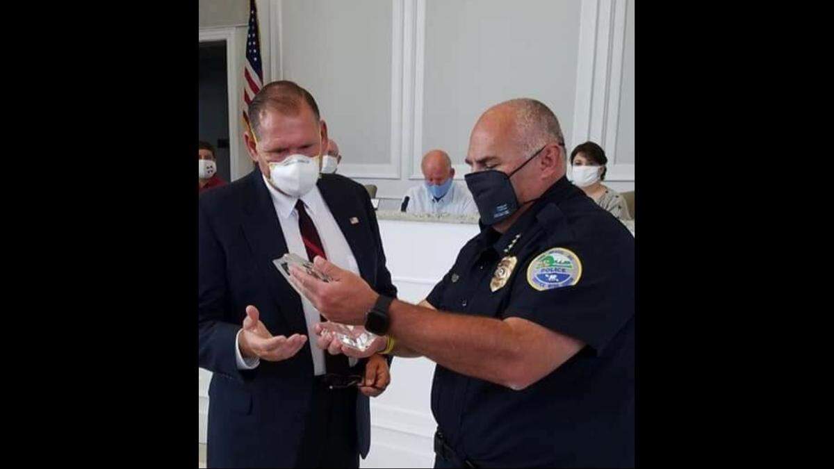 Retired Long Beach Police Officer Craig DeRouche is pictured here, left, receiving a plaque honoring his longtime service as a police officer in Mississippi.
