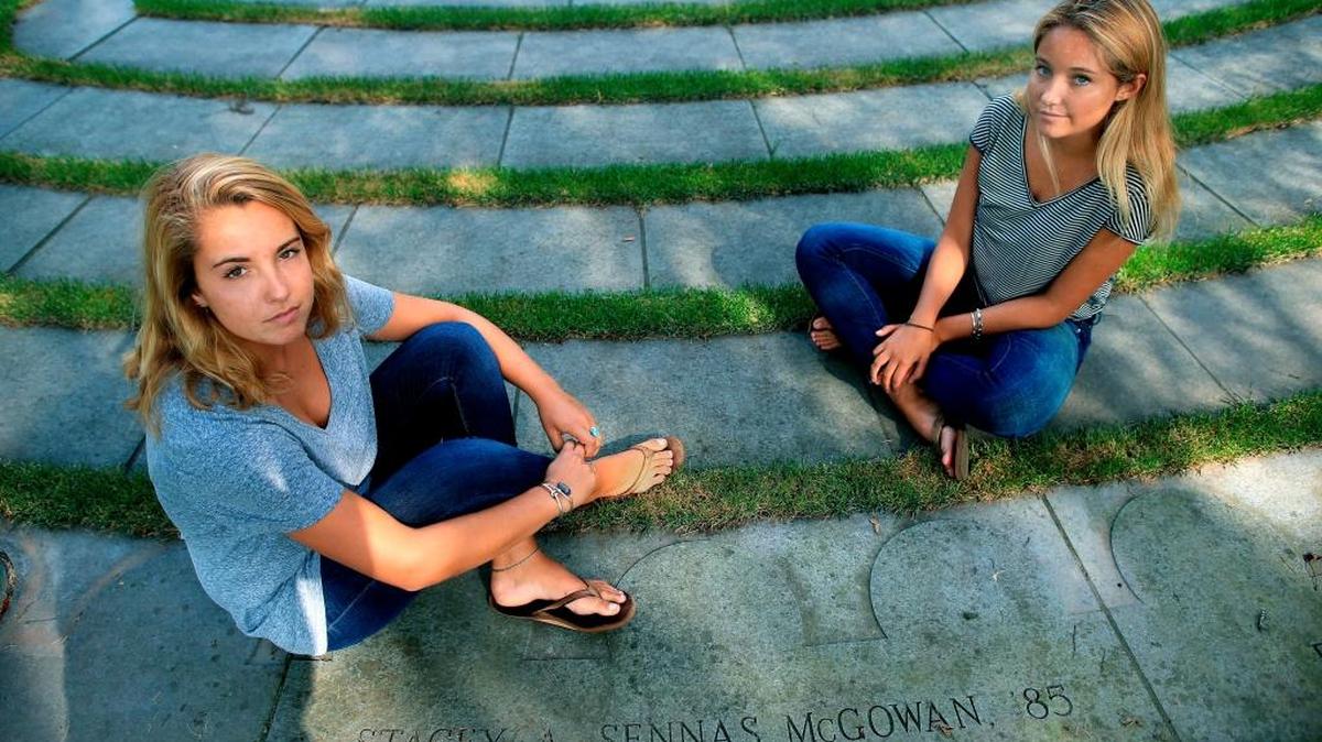 Sisters Ryan, left, and Casey McGowan sit beside the stone honoring their mother on the Boston College campus in Boston on Sept. 4, 2015. Their mother, Stacey Sennas McGowan, was killed on during the attacks on the World Trade Center on Sept. 11, 2001, in New York.