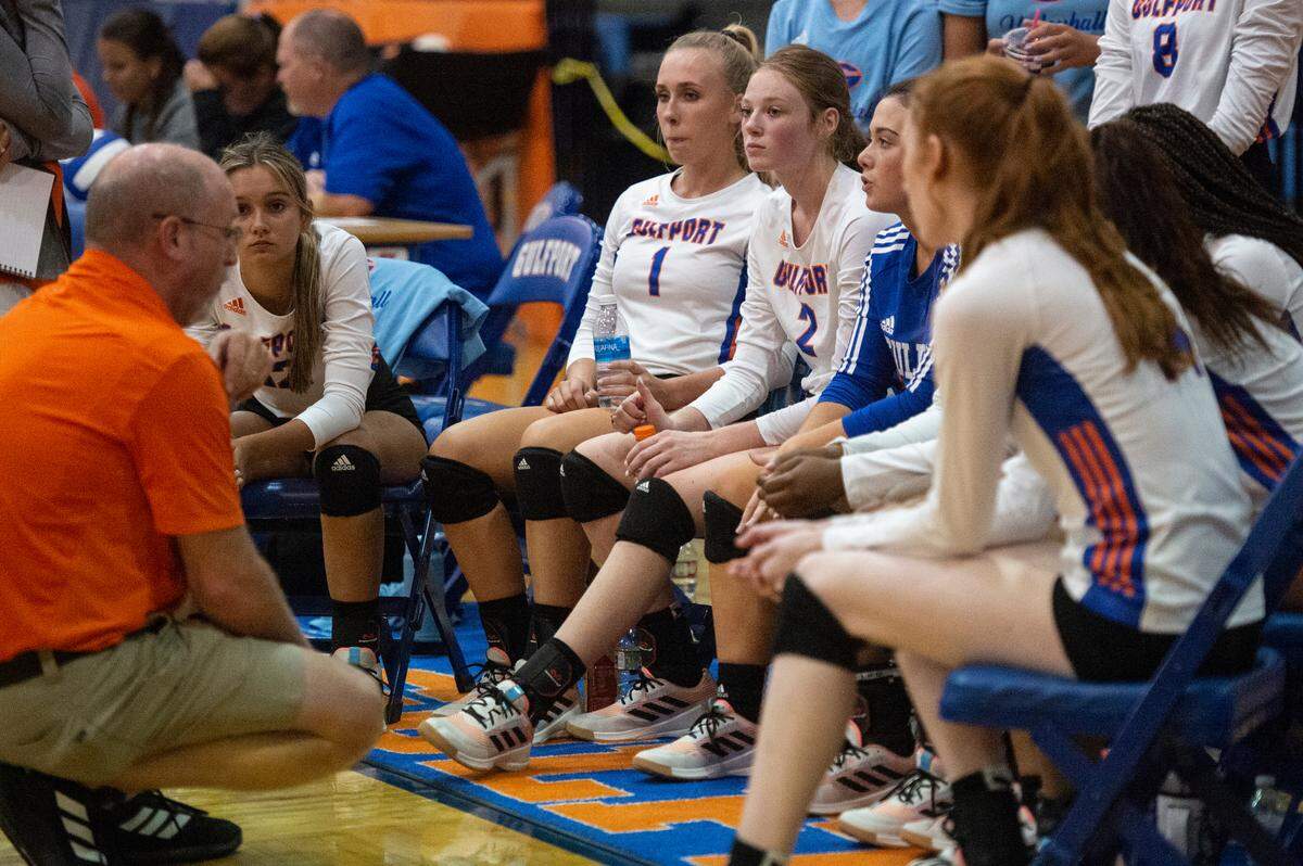 The Gulfport varsity volleyball team listens to their coach, David Irwin, during a time out in a match against Ocean Springs at Gulfport High School in Gulfport on Tuesday, Oct. 4, 2022.