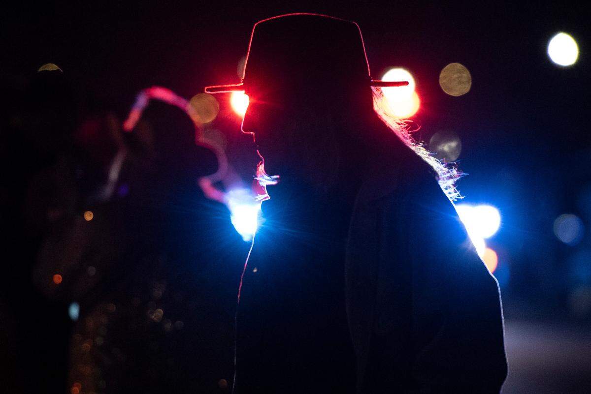 A parade attendee crosses the street as police lead Mystic Krewe of the Seahorse’s Lundi Gras parade down Beach Boulevard in Bay St. Louis on Monday, March 3, 2025.