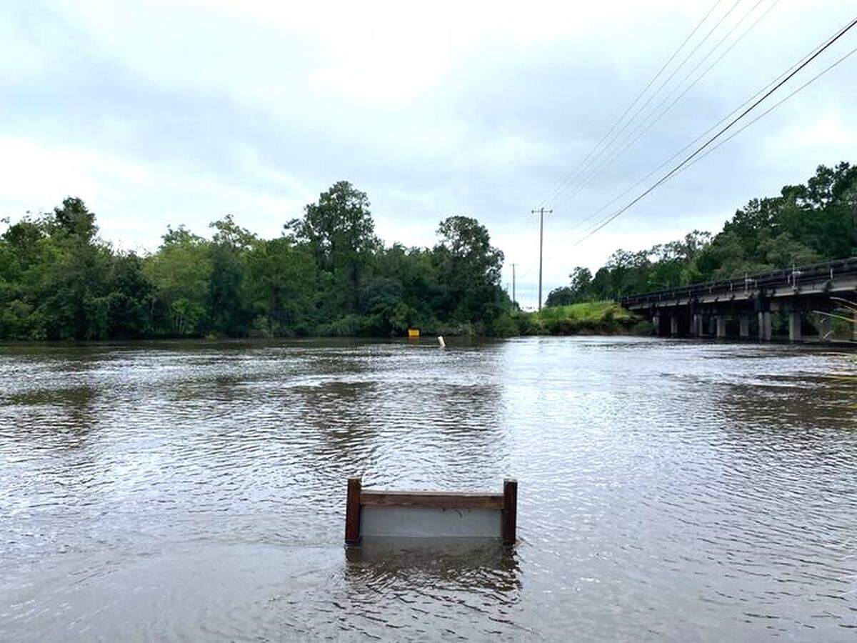 The Jourdan River floods above a sign on Thursday, after Hurricane Francine.