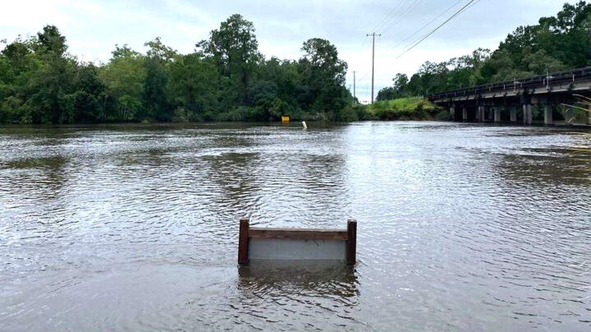 The Jourdan River floods above a sign on Thursday, September 12, 2024 after Hurricane Francine.