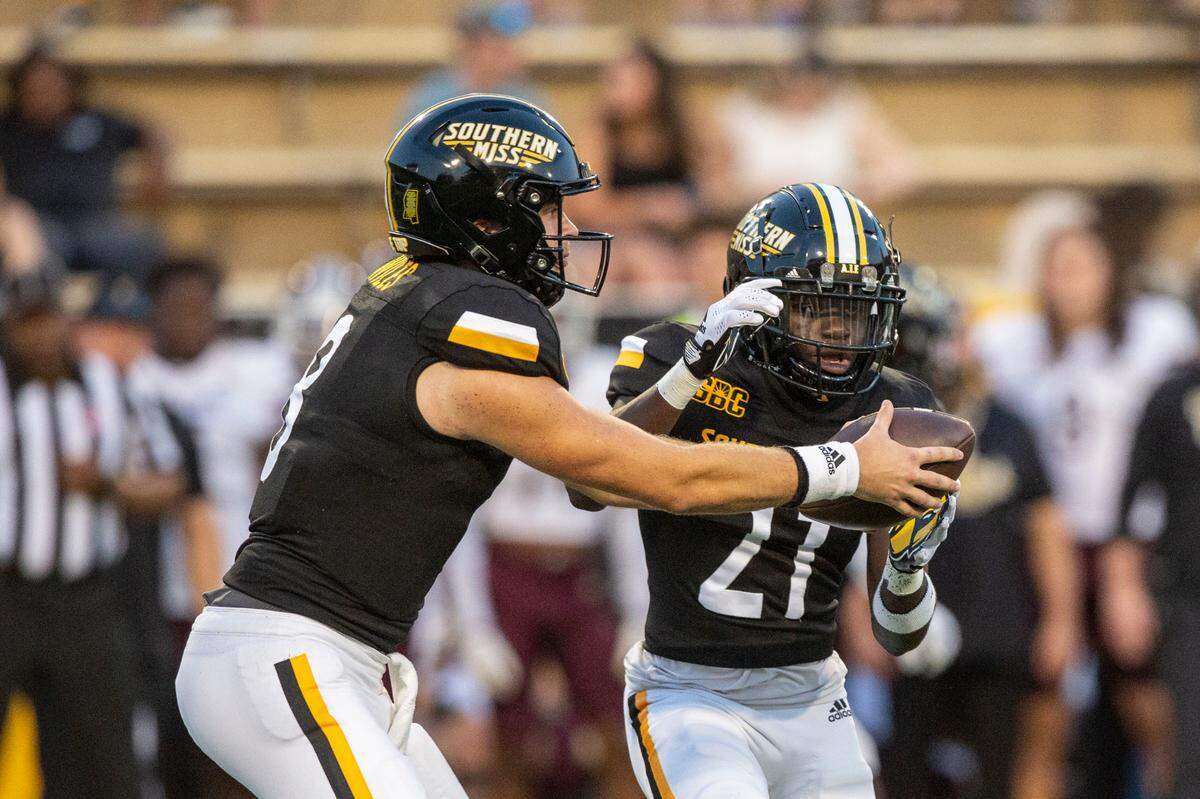 Southern Miss Golden Eagles quarterback Billy Wiles (8) hands the ball off to Southern Miss Golden Eagles wide receiver Tiaquelin Mims (21) during a game against Texas State at M.M. Roberts Stadium in Hattiesburg on Saturday, Sept. 30, 2023.