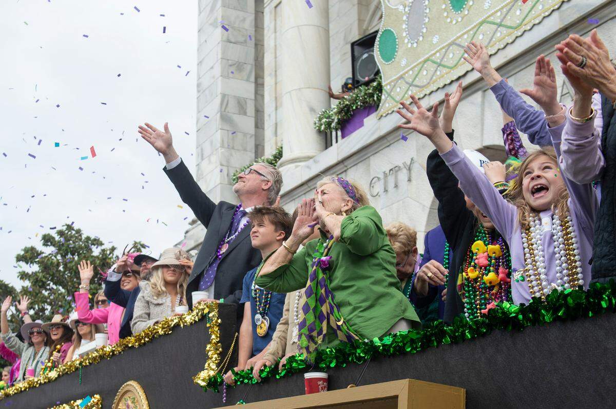 Parade watchers cheer for beads and other throws during the Gulf Coast Carnival Association Mardi Gras parade in Biloxi on Tuesday, March 4, 2025.