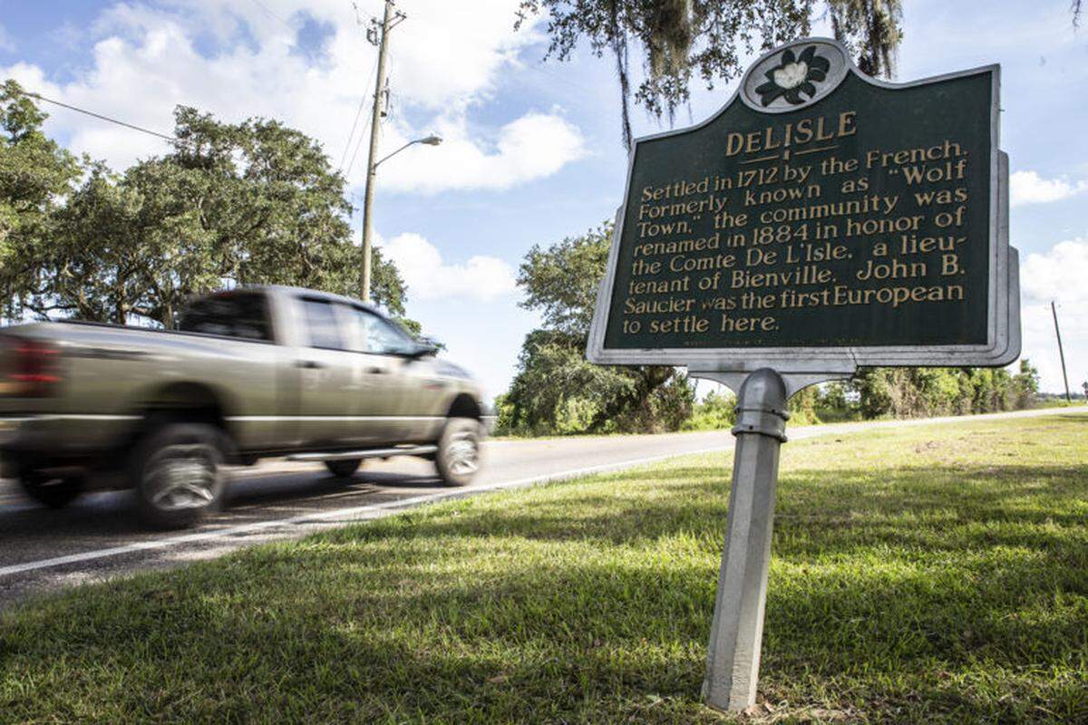 A truck passes DeLisle historical marker. DeLisle is the hometown of novelist Jesmyn Ward.