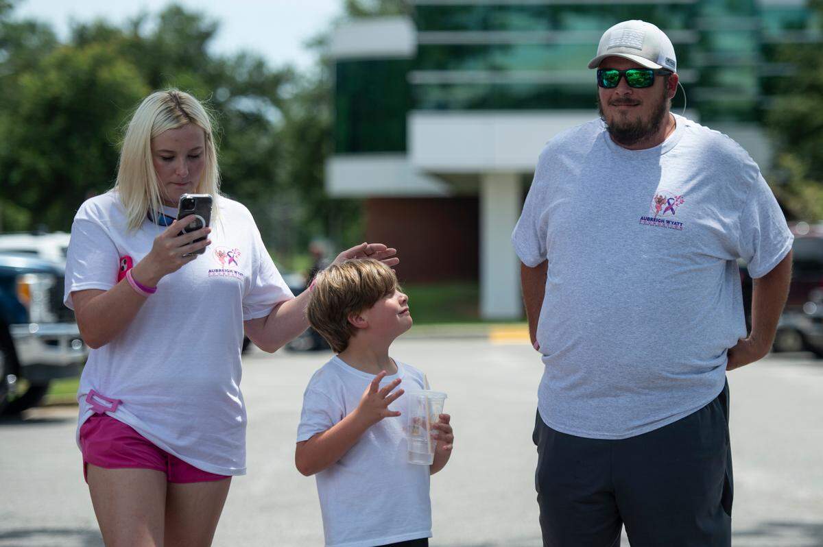 Heather Wyatt’s son Ryker, 7, waits outside the Jackson County courthouse in Pascagoula with his father Dexter Woods and his stepmother on Thursday, July 18, 2024. During the time Heather Wyatt was court ordered to stop using social media, Woods posted videos about the family.