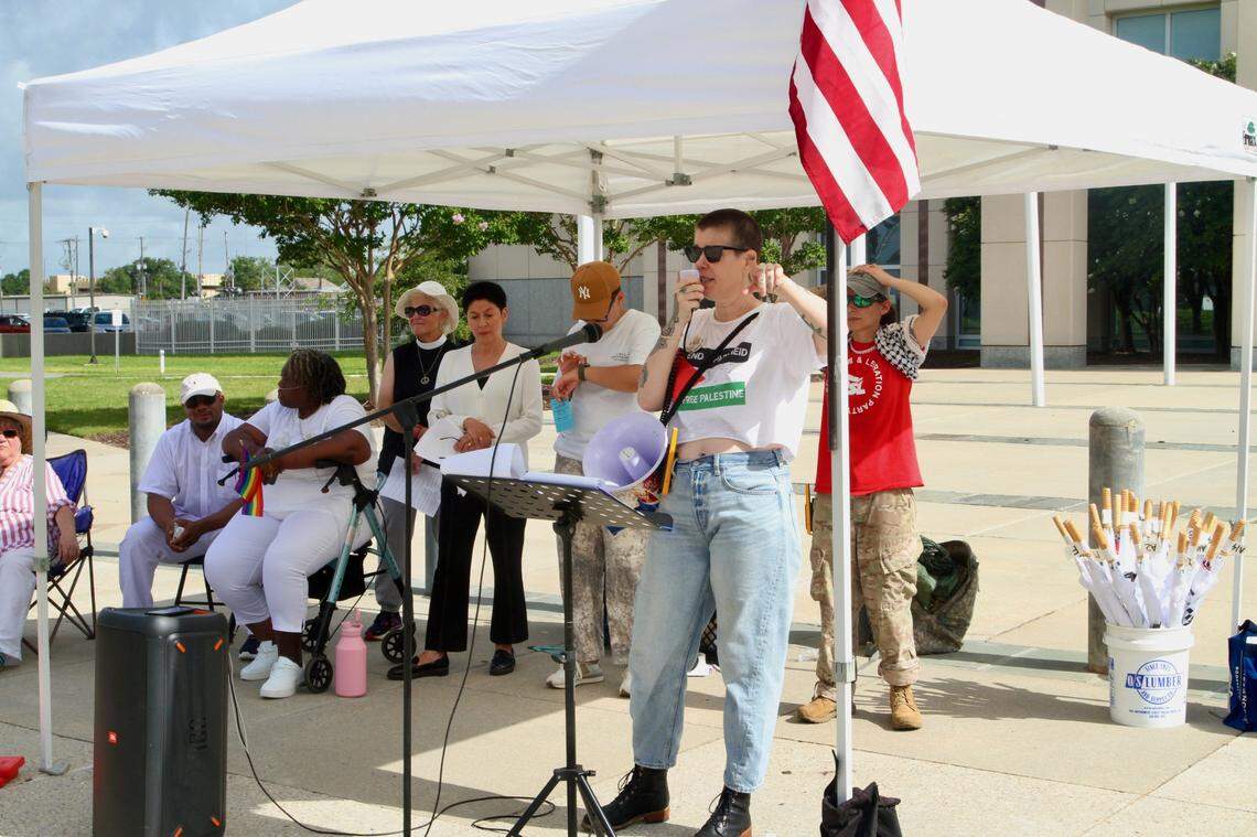 Lea Campbell of the Mississippi Rising Coalition speaks out against the Trump administration at the “No Kings” protest Saturday in Gulfport while other speakers wait their turns to address the peaceful crowd of 500 or more.