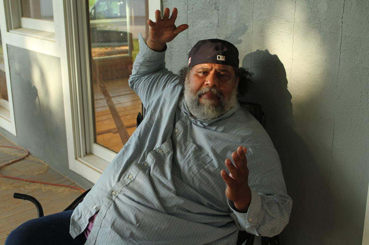 Derrick Evans, a sixth-generation member of the Turkey Creek community, talks about restoration of the old building where he sits on the back porch, the former paymaster’s office that survived a deadly explosion in 1943 at the Phoenix Naval Stores plant. Evans and others are working to preserve the community founded in 1866 by freed slaves and threatened today by Coastal sprawl.