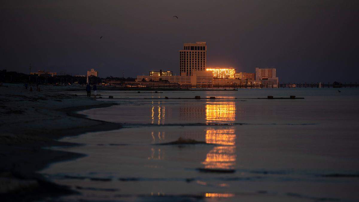 The setting sun reflects off the casinos in Biloxi on Wednesday, Sept. 22, 2021.