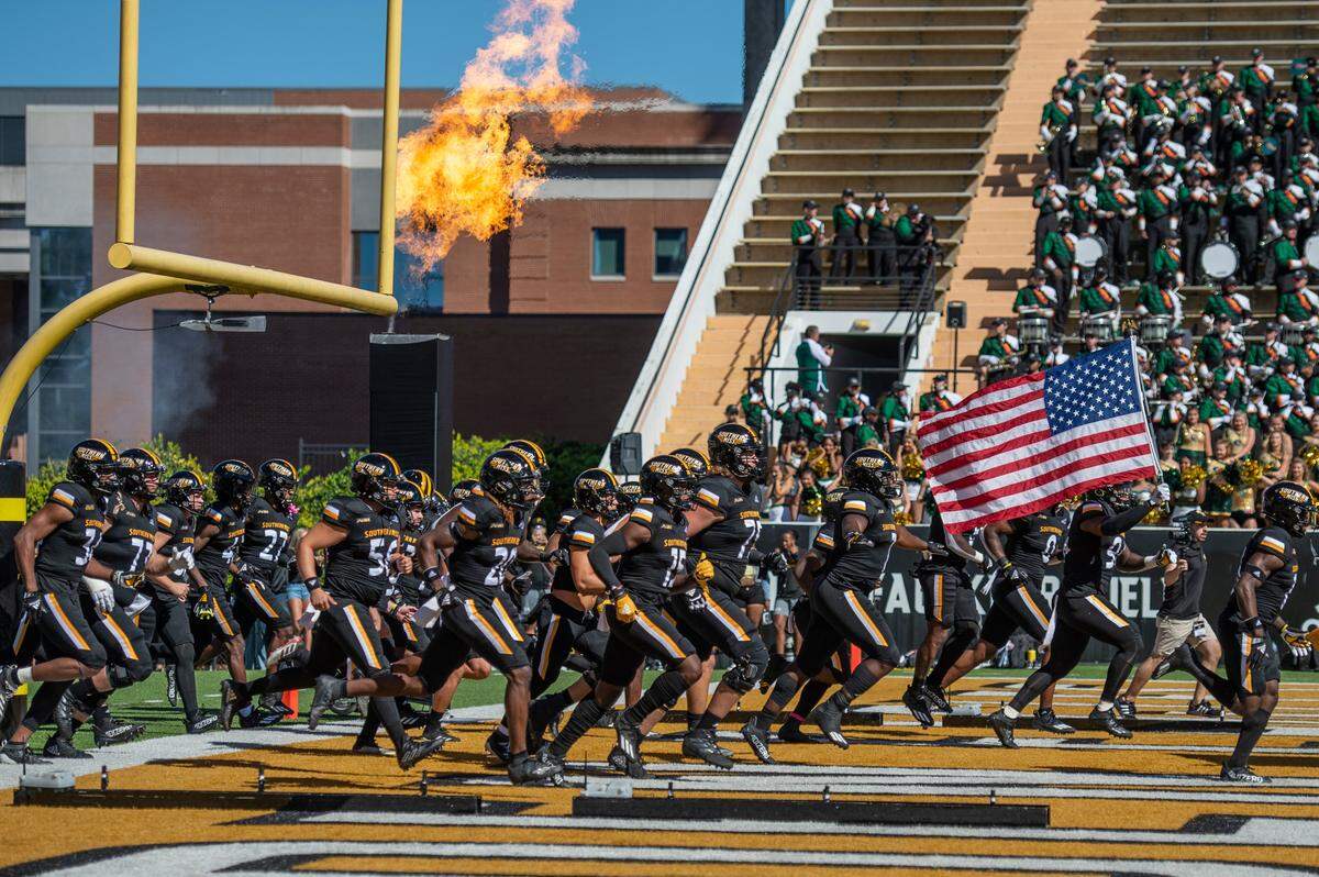 The Southern Miss Golden Eagles run onto the field before their game against the University of Alabama-Birmingham Blazers at M.M. Roberts Stadium in Hattiesburg on Saturday, Oct. 16, 2021.
