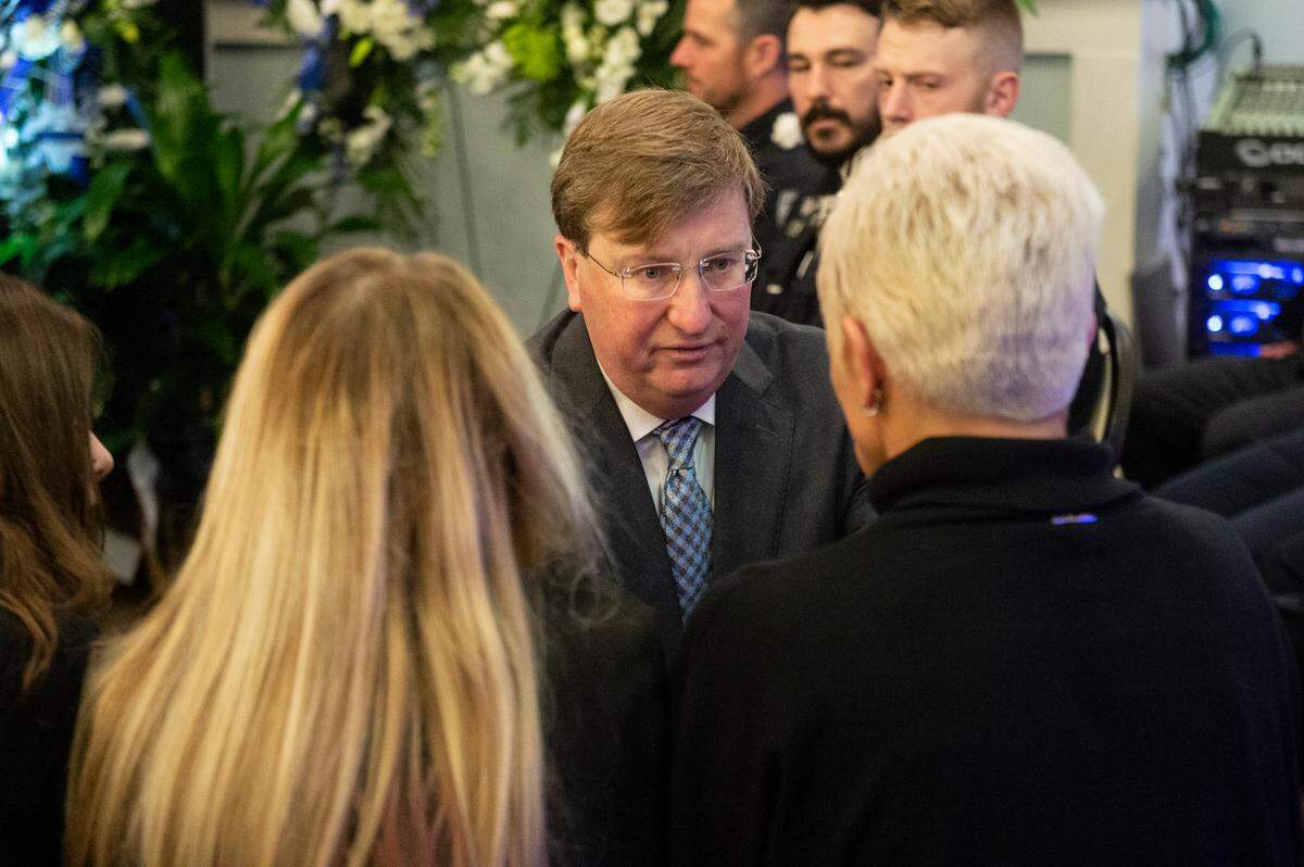 Gov. Tate Reeves presents a folded Mississippi state flag to the family of fallen officer Branden Estorffe during the funeral for Bay St. Louis police officers Sgt. Steven Robin and Branden Estorffe at the Bay St. Louis Community Center in Bay St. Louis on Wednesday, Dec. 21, 2022. Robin and Estorffe were killed responding to a call at a Motel 6 on Dec. 14.