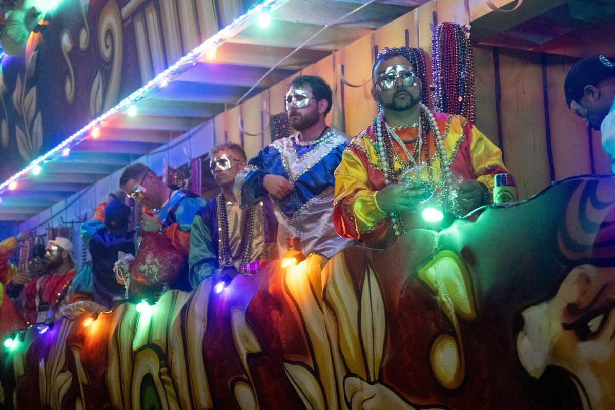 Parade participants pass out Mardi Gras beads and other items during the Krewe of Neptune parade in Biloxi on Saturday, Feb. 14, 2026.