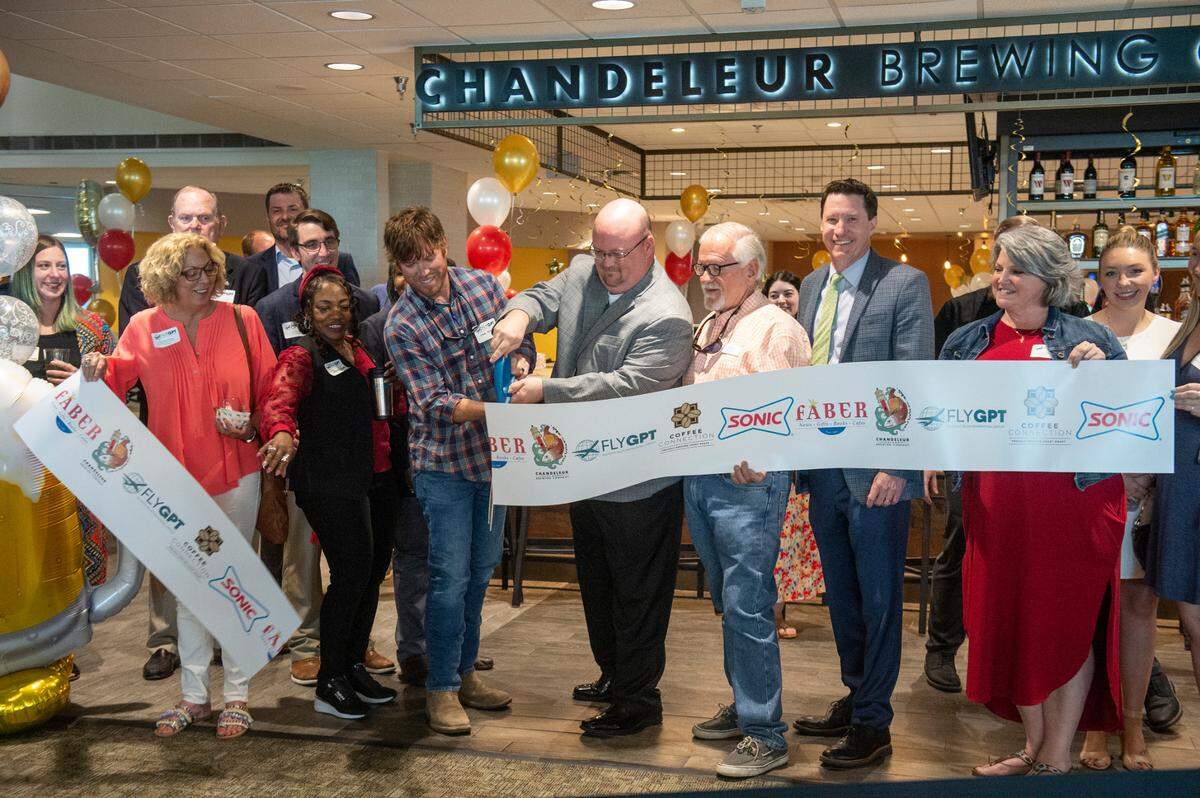 Representatives from the City of Gulfport, the Gulfport-Biloxi Airport, Chandeleur Brewing and others cut the ribbon for several new food offerings during the grand opening at Gulfport-Biloxi International Airport that opened on Wednesday, April 26, 2023.