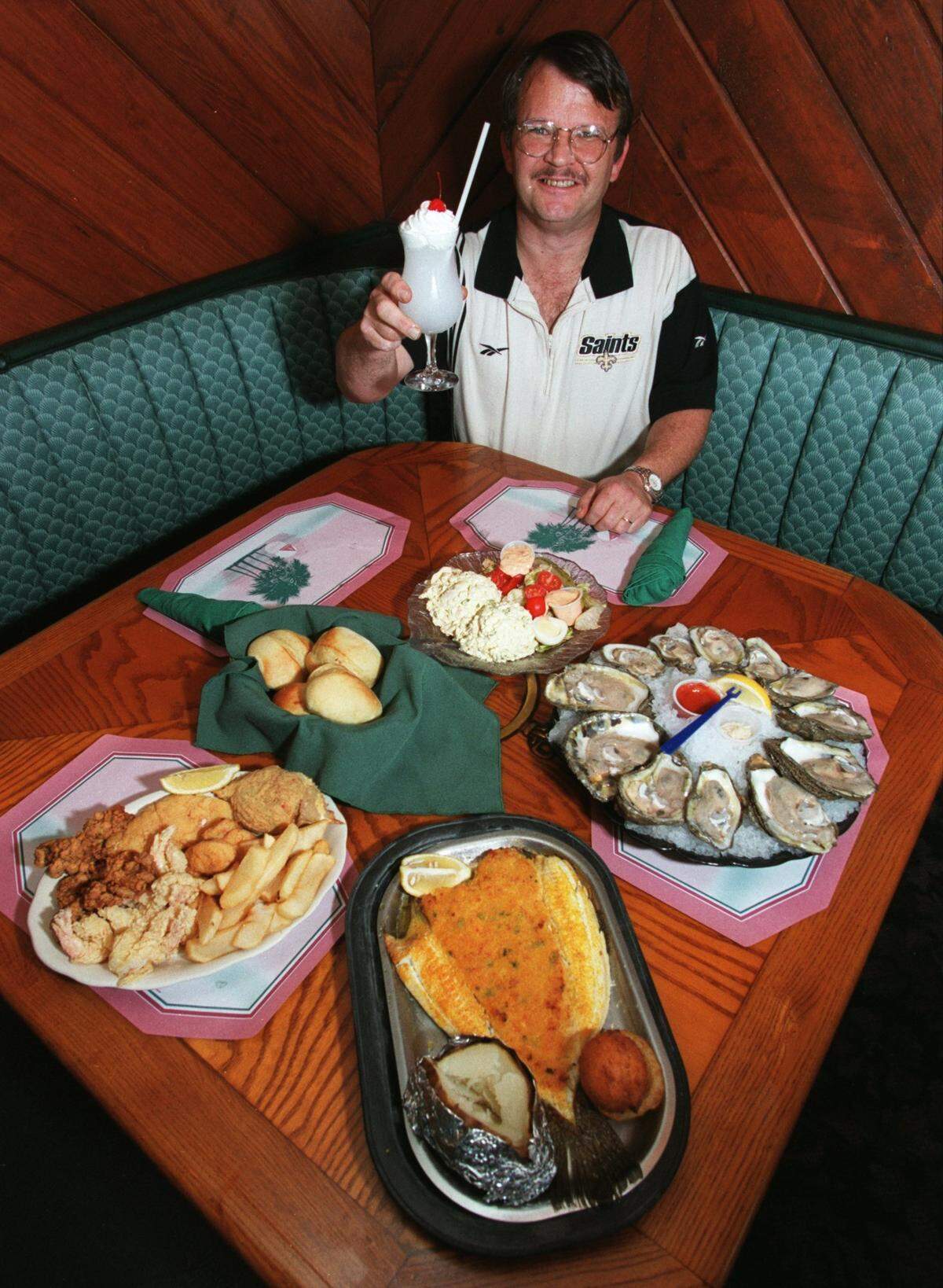 Hook, Line & Sinker manager Terry Shelton shows off some of the Biloxi restaurant’s specialties including from left, seafood platter, stuffed flounder and raw oysters. The restaurant also features a lounge with a big-screen TV, great for watching sporting events.