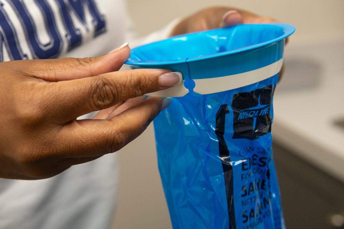 Nurse practitioner Ashley Thompson holds an emesis bag for vomiting patients at her practice at a Memorial Health walk-in in Gautier on Wednesday, Jan. 15, 2025. Thompson says she’s seen an increase in norovirus cases, the symptoms of which include nausea, vomiting and diarrhea.