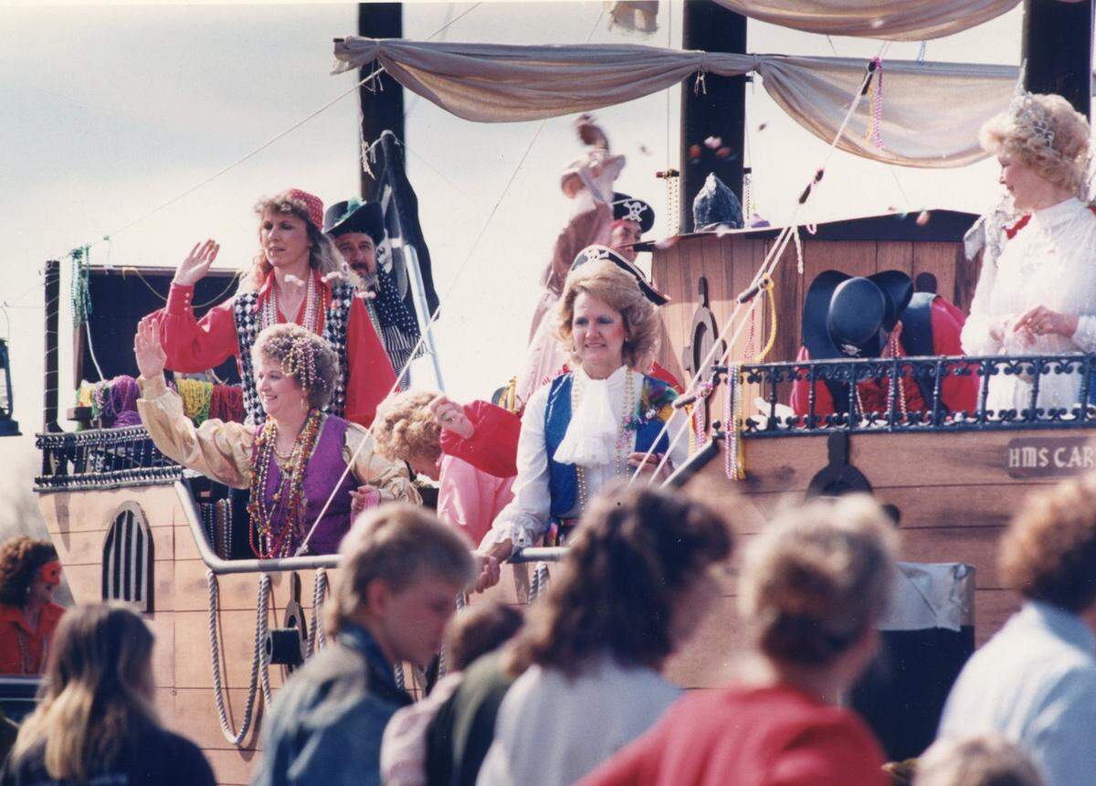 A krewe of pirates waves and throws favors to the crowd at the Elks Mardi Gras Parade in Ocean Springs in 1990.