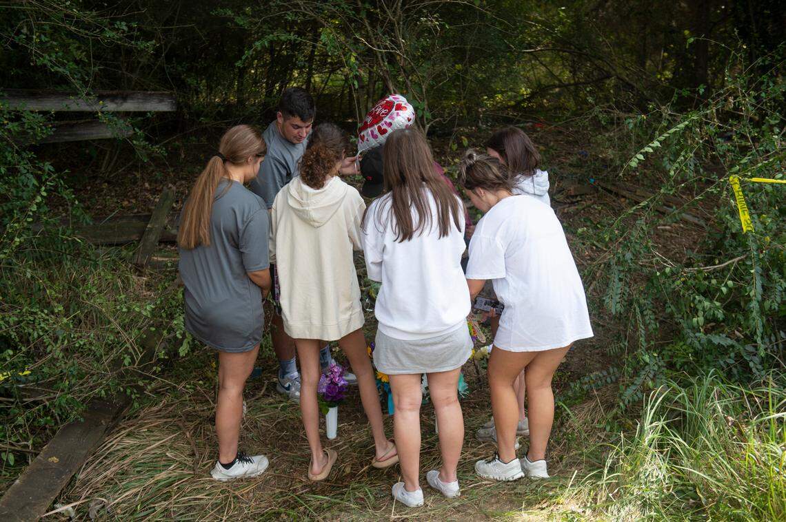 The friends and cousins of Baleigh Bowlin and Chloe Taylor put flowers at a memorial for the girls at the site of a fatal car accident that claimed the lives of both girls off of Highway 613 in Hurley on Monday, Oct. 17, 2022.
