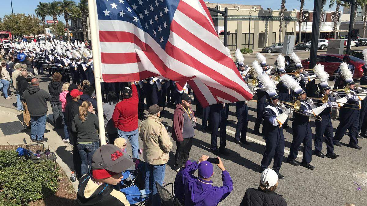 Ellis Graham holds a flag as he watches the Gulf Coast Veterans Day parade in downtown Gulfport on Saturday, Nov. 10, 2018. 