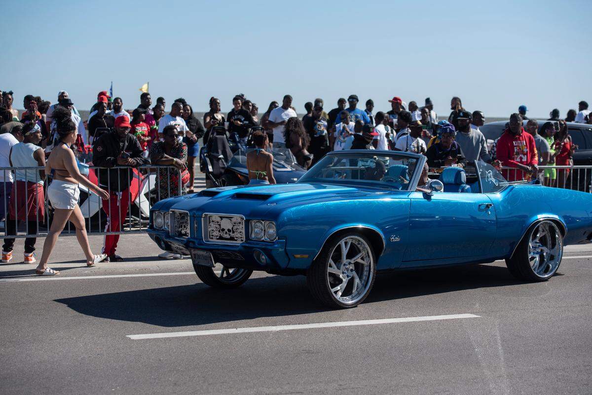 Spring breakers look at cars driving along Beach Boulevard during Black Spring Break in Biloxi in 2022.