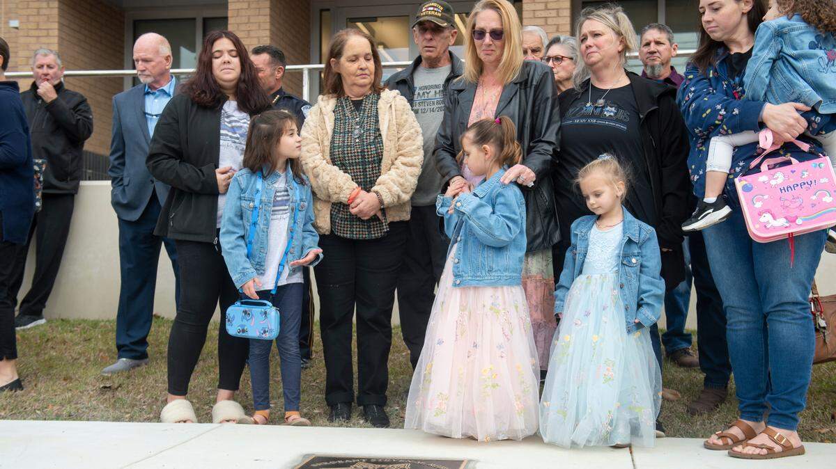 Members of Steven Robin’s family remove a sheet covering a metal star during a ceremony dedicating commemorative stars in honor of Sergeant Steven Robin and Officer Branden Estorffe outside the new Bay St. Louis Police Department in Bay St. Louis on Thursday, Dec. 14, 2023. Estorffe and Robin were killed on Dec. 14, 2022 by a local veterinarian when they responded to a call at a Motel 6.
