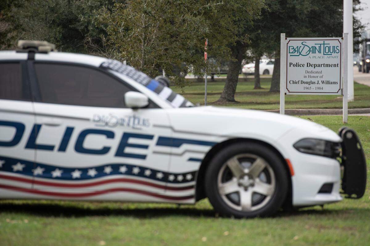 A police car with a thin blue line flag sits outside the Bay St. Louis Police Station in honor of officers Steven Robin and Brandon Estorffe who were killed in the line of duty on Wednesday, Dec. 14, 2022.