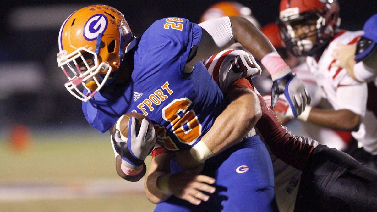 TIM ISBELL/SUN HERALD 
 Gulfport running back Deon Cole drags Harrison County defenders for a first down, Friday, Oct. 16, 2015.